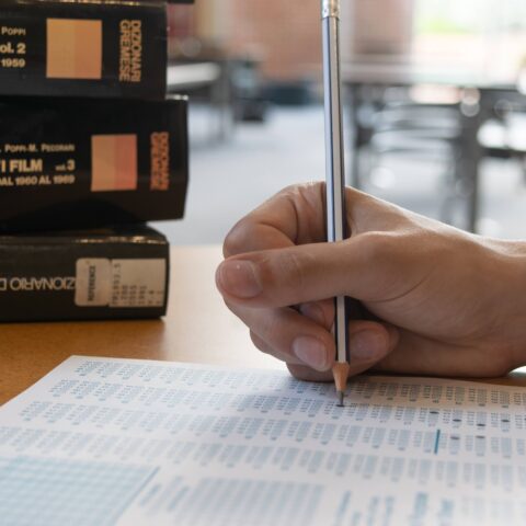 Hand fills out bubbles on a scantron