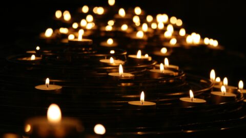 Candles burn in darkness