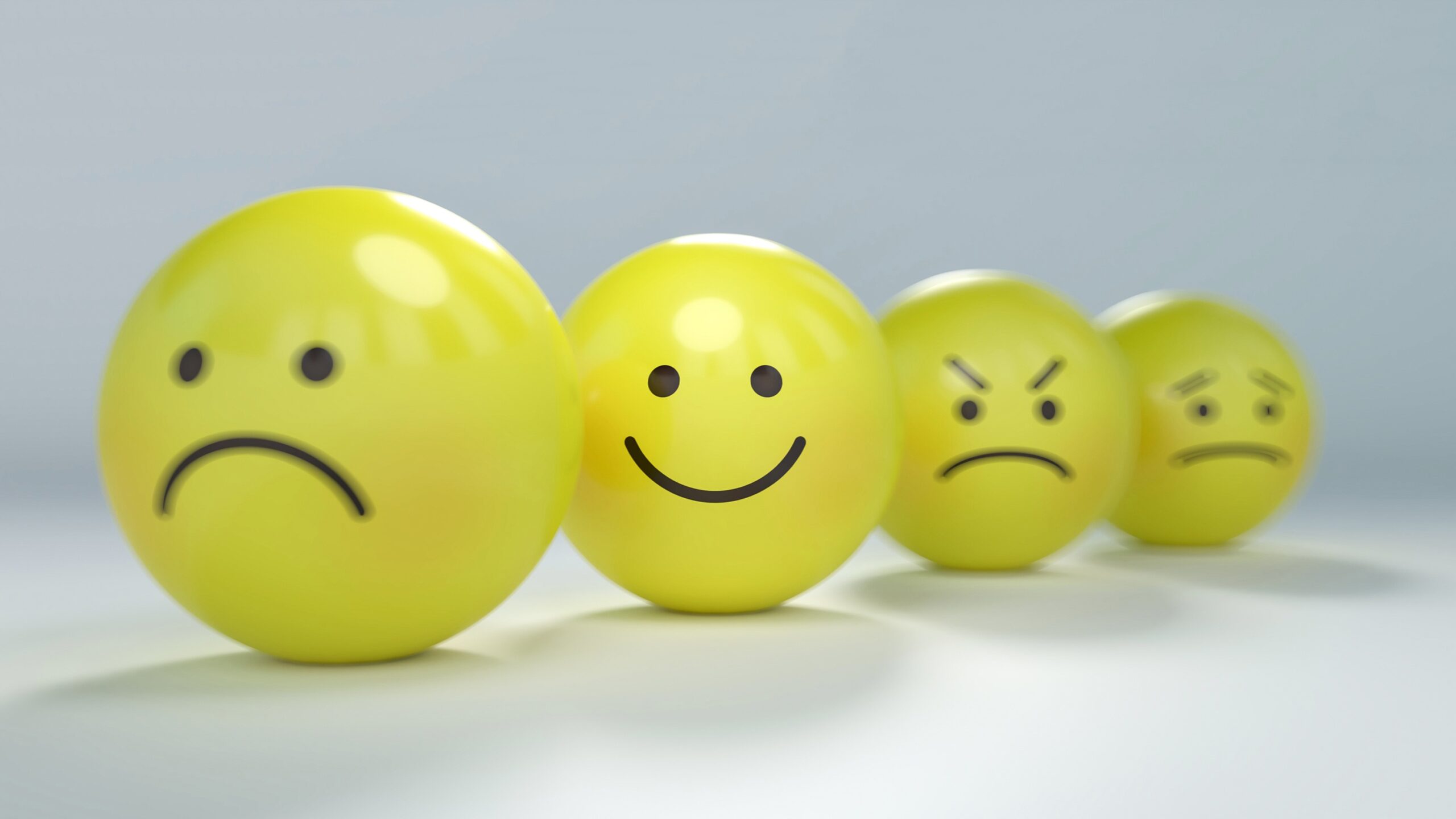 yellow balls with unhappy faces and one happy face